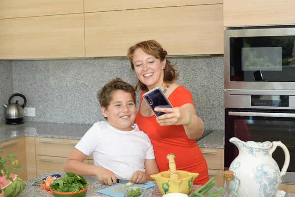 Feliz madre e hijo preparando el almuerzo mientras toman un "selfie" — Foto de Stock
