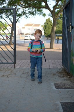 5 yaşında kızıl saçlı çocuk okula giriyor. Biraz üzgün.