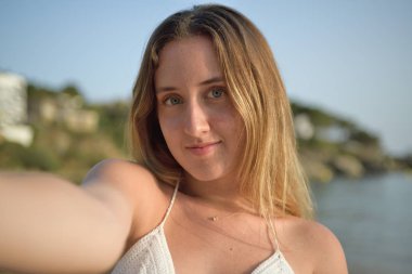 Sahilde selfie çeken bir kızın yakın portresi