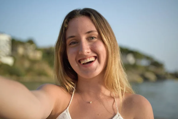 De cerca retrato de una chica riendo y tomando selfie en la playa — Foto de Stock