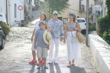 Bir Akdeniz köyünün sokağında dört mutlu insan