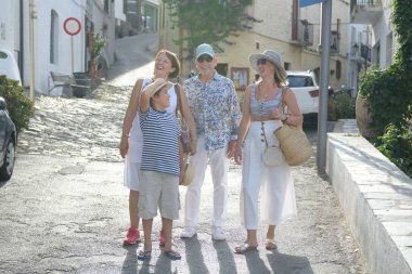 Bir Akdeniz köyünün sokağında dört mutlu insan