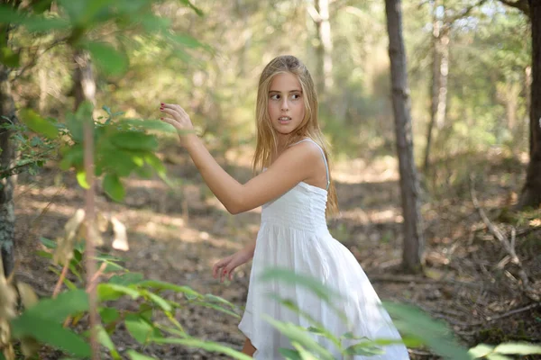 Chica asustada corriendo a través de un bosque y mirando hacia atrás — Foto de Stock