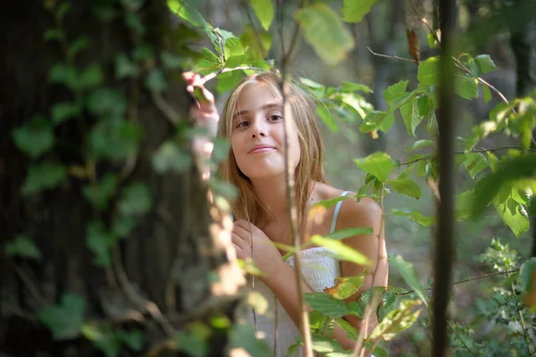 Girl in a forest in a white dress looking at the camera — Stock Photo, Image