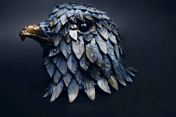 Closeup of stylish metal head-wear in shape of bird head, grey background