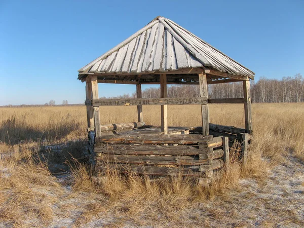 シベリアロシアの青い空の下でのコムギ畑 部屋は農場の木と板でできている 1月の小麦畑の木造避難所 — ストック写真