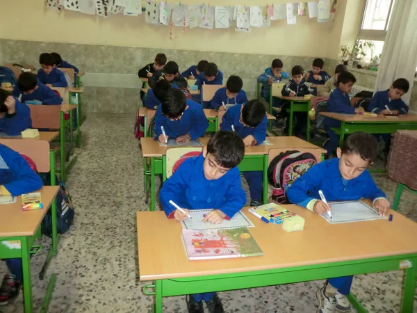  İlkokul çocukları Gilan İran. Rasht, Guilan eyaletinde, İran'da ilkokul çocuklarından biri. Öğrenciler okul üniforması giyiyor. Öğrenciler kağıda yazmakla meşguller..