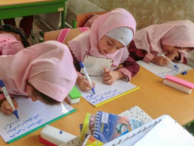 Rasht, Guilan eyaletinde, İran'da ilkokul kızlarından biri. Kızların eşarp giymesi ve üniforma giymesi gereken bir İslam okulu.