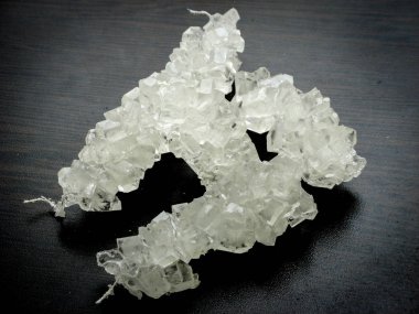 White nabat with black background , Iranian rock candy on a wooden table. It is made of crystallization of sugar. Nabat is an Iranian dessert consumed with tea or coffee. Iranian culture clipart