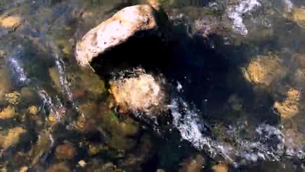 カラフルな岩から川の水の流れ 川の水の流れの下の石 川の水の流れに太陽の光 — ストック動画