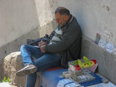 Bir falcı oturup bir şeyler yazıyor, İran, Gilan..