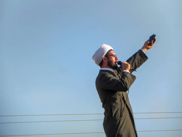 Kerbela, Bağdat, Irak,06 09 2019: Şii Müslüman bir vaizin konuşması. Mavi gökyüzü arka plan ile özel giyim Şii din adamı.