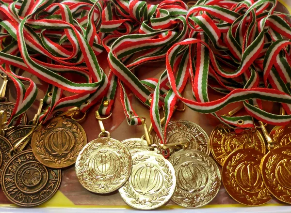 Altın, gümüş, kırmızı, beyaz ve yeşil kurdeleli bronz spor madalyası. Kazanan ödülleri. Madalyalar üzerindeki metnin çevirisi 