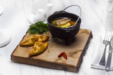 Börek ile servis edilen bir kapta lezzetli balık çorbası