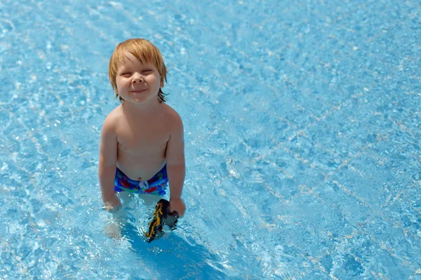 Маленький розслаблений симпатичний хлопчик з окулярами у теплій воді басейну — стокове фото