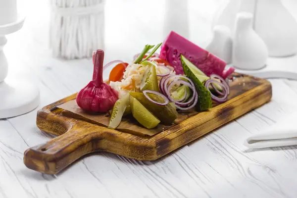 Νόστιμα φρέσκα και τουρσί λαχανικά σε μια σανίδα — Φωτογραφία Αρχείου