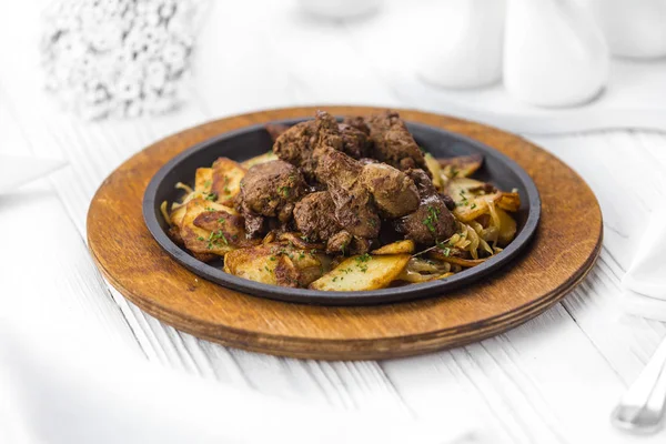 Carne frita con rodajas finas de patata en un plato —  Fotos de Stock