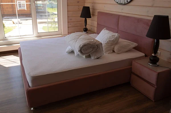 Велике двоспальне ліжко з двома білими подушками та біла ковдра в розкішному готелі Стокова Картинка
