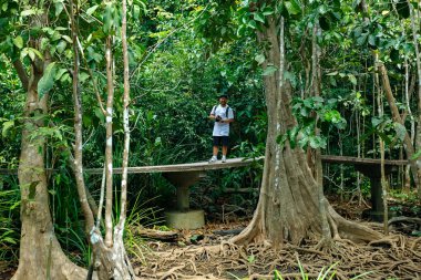 Genç bir adam seyahat ederken fotoğraf çeker.