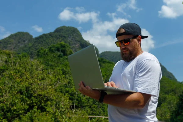 Νέος στιλάτος blogger με γένια που εργάζεται σε διακοπές στα βουνά. — Φωτογραφία Αρχείου