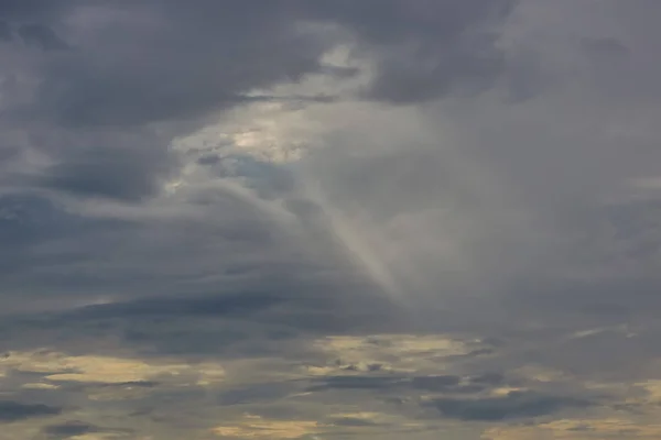 The sun's rays at sunset making their way through the clouds.