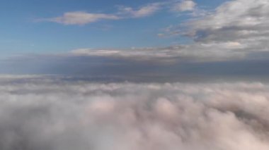 Yerin üstündeki bulutlarda güzel uçuşlar. Mavi gökyüzüne bakan.