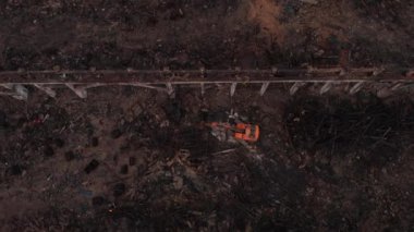 Ekskavatör üzerinde uçan eski fabrikanın duvarları yok.