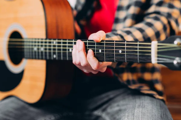 Guitar player. Selective focus of male fingers touching strings while playing the guitar