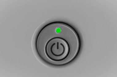 Ev aletlerindeki güç düğmesi, yanan yeşil bir sinyal ile yakın plan..