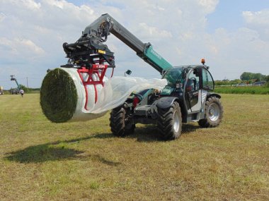 Kramer telehandler bir balya işleyicisi ile dolu bir balya kaldırma.