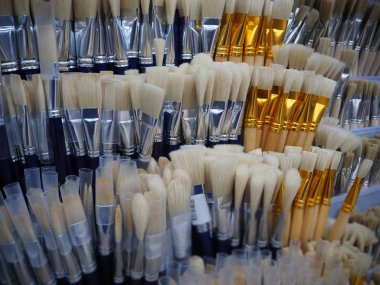 Sanat atölyesinde resim yapmak için beyaz ve mavi fırçalar