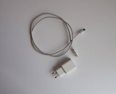 Akıllı telefonun üst görünümünü şarj etmek için beyaz usb şarj cihazı