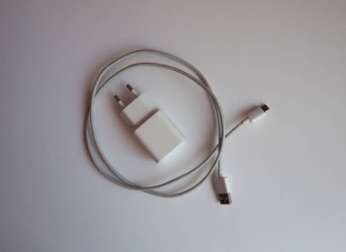 Akıllı telefonun üst görünümünü şarj etmek için beyaz usb şarj cihazı