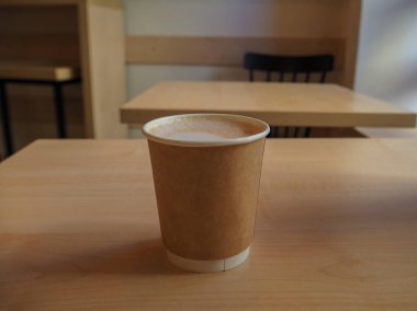 Kafede ahşap masada kağıt paket fincan kapuçino Fincan