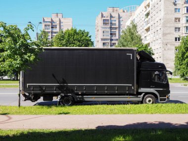 Şehir caddesinde duran siyah kamyon 