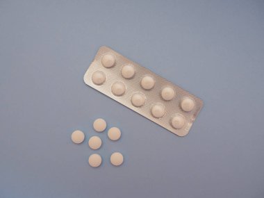 Mavi arka planda beyaz ilaç hapları. Kopya uzay görüşlü hastalıkları önlemek ve tedavi etmek için kullanılan modern ilaçlar. Opioid salgını, ağrı kesiciler ve uyuşturucu bağımlılığı konsepti.