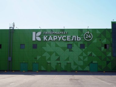 Saint-Petersburg, Rusya. 07.07.2019. Soyut yeşil geometrik üçgenler desen tasarımı ve beyaz logolu hipermarket Karusel binasının cephesi. Marka X5 Retail Group, önde gelen Rus gıda perakendecisi aittir. 