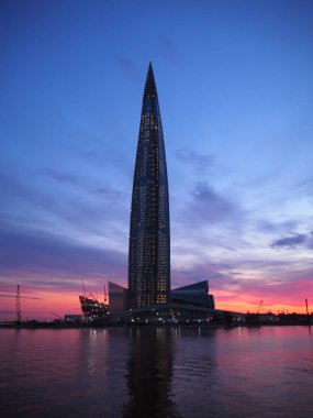 St. Petersburg, Rusya, 07.03.2019. Güzel gün batımında ünlü gökdelen Lakhta merkezi. Alacakaranlık çok renkli pembe ve deniz suyunda renkli yansıma ile mavi gökyüzü. Akşam karanlığı üzerinde panoramik deniz manzarası.