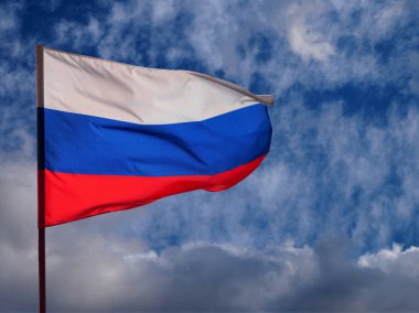 Yıldırım bulutlar ve mavi gökyüzü arka planda rüzgar sallayarak Rusya Federasyonu Ulusal Tricolor bayrağı 