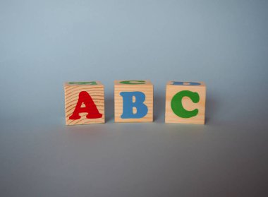 Metin ile ahşap alfabe oyuncak blokları: abc. Yalıtılmış çocuklar kopya alanı ile mavi arka plan üzerinde çok renkli Abc küpleri. Okul konseptine geri dön.