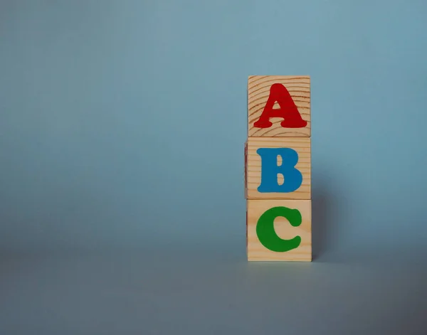 テキストと木製のアルファベットのおもちゃのブロック Abc コピースペースを持つ青い背景に孤立した子供の多色Abcキューブ 学校の概念に戻る — ストック写真