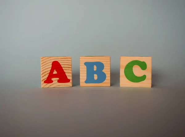 テキストと木製のアルファベットのおもちゃのブロック Abc コピースペースを持つ青い背景に孤立した子供の多色Abcキューブ 学校の概念に戻る — ストック写真