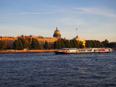 Saint-Petersburg, Rusya. 08.31.2019. Gün batımında turist teknesi ile Aziz İshak Katedrali ve Neva Nehri manzarası. Nehirler ve kanallar boyunca deniz gezileri.