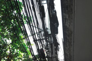 Elektrik direkleri üzerinde darmadağın olan elektrik hatları ve kablolar