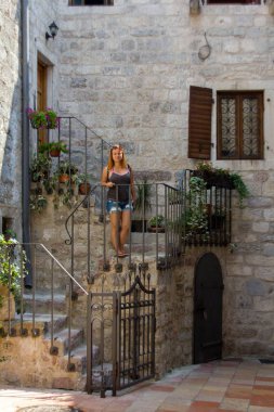 Kotor, Karadağ, Nisan 2017, Kotor, Karadağ'ın eski kasabasında, eski taş evleri ve çok dar sokakları ile sokakta yürüyen kız 