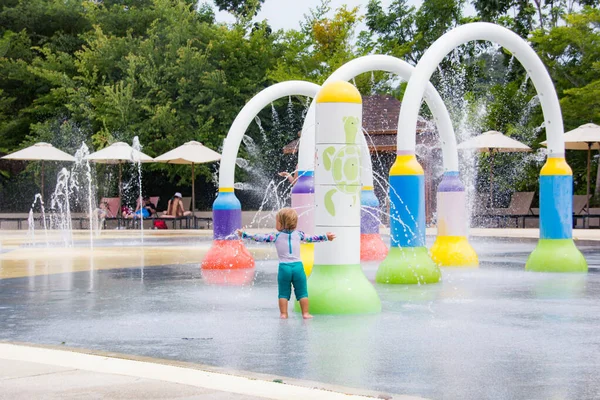 Bambino gioca nel parco acquatico all'esterno — Foto Stock