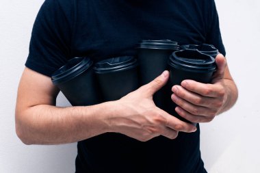 Kafkasyalı adam elinde siyah kahve fincanları tutuyor. Gizli ellerde, yüzü gizli.,