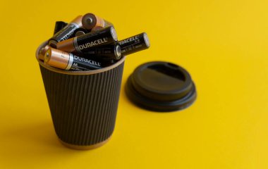 Closeup at duracell AA alkaline batteries in takeaway coffee cup clipart
