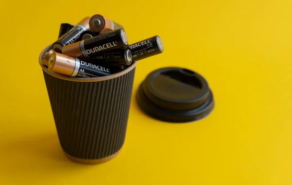 Κλείσιμο σε αλκαλικές μπαταρίες Duracell AA σε φλιτζάνι καφέ takeaway Εικόνα Αρχείου