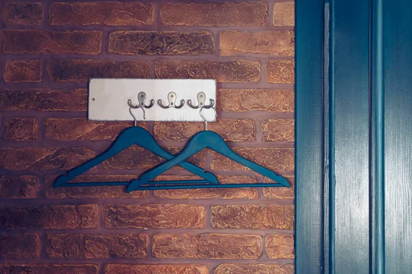 ドアの近くのレンガの壁にかかってフックに2色のハンガー、創造的なロフトスタイル, — ストック写真